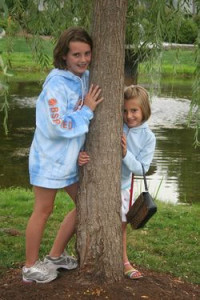 kids leaning on a tree