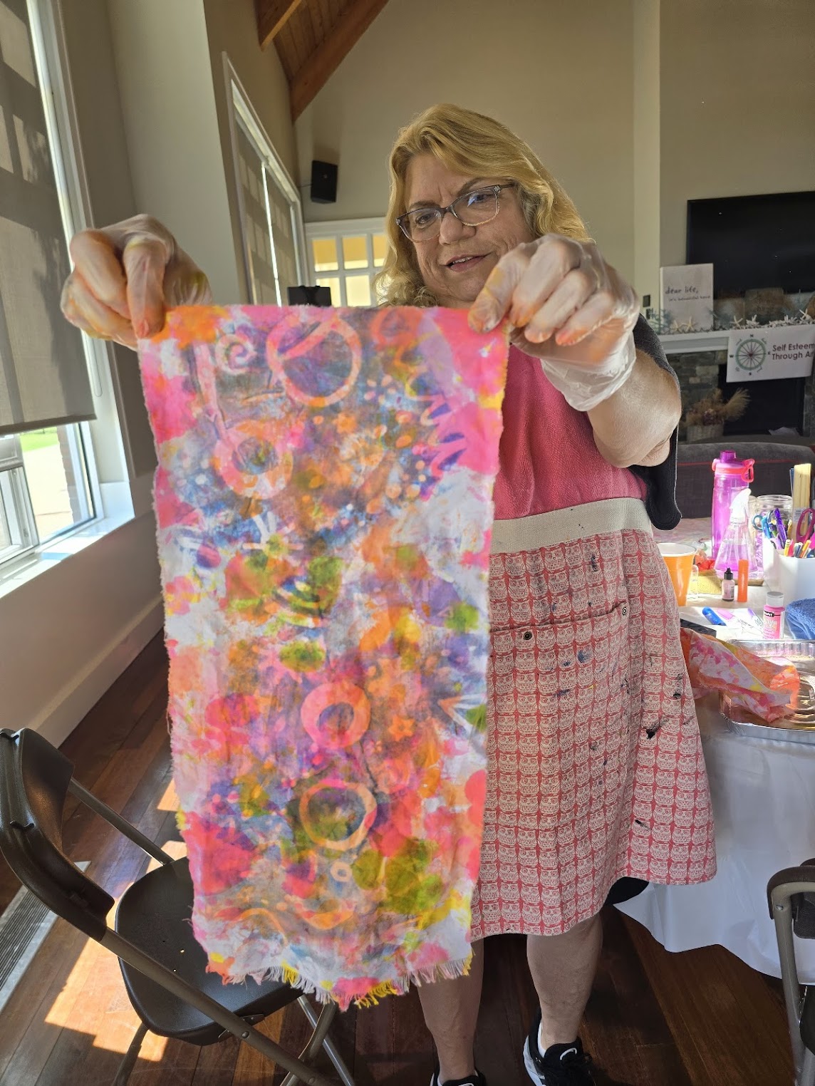 a woman holding her painted and altered fabric