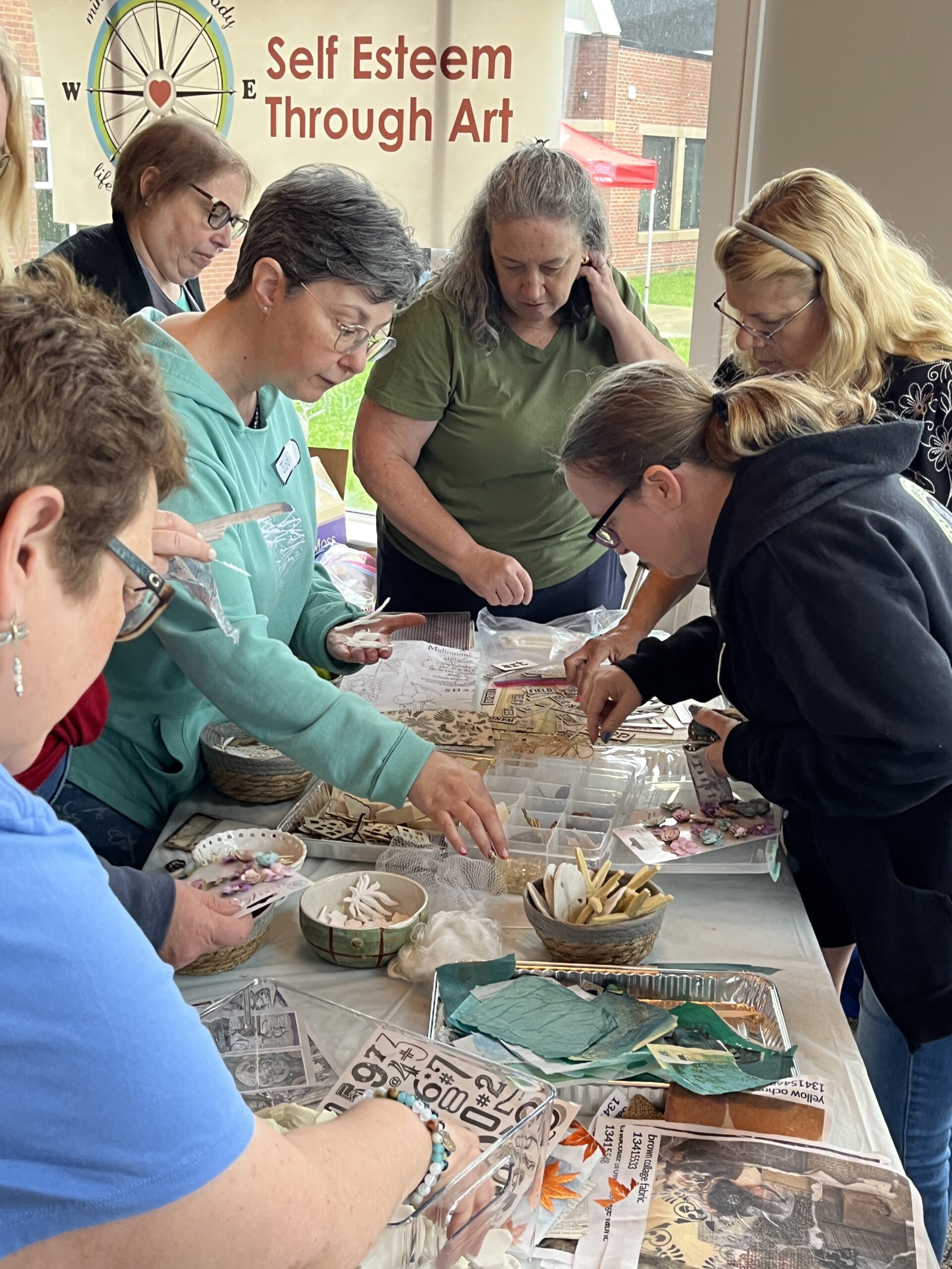 a group of women selecting materials for an art class